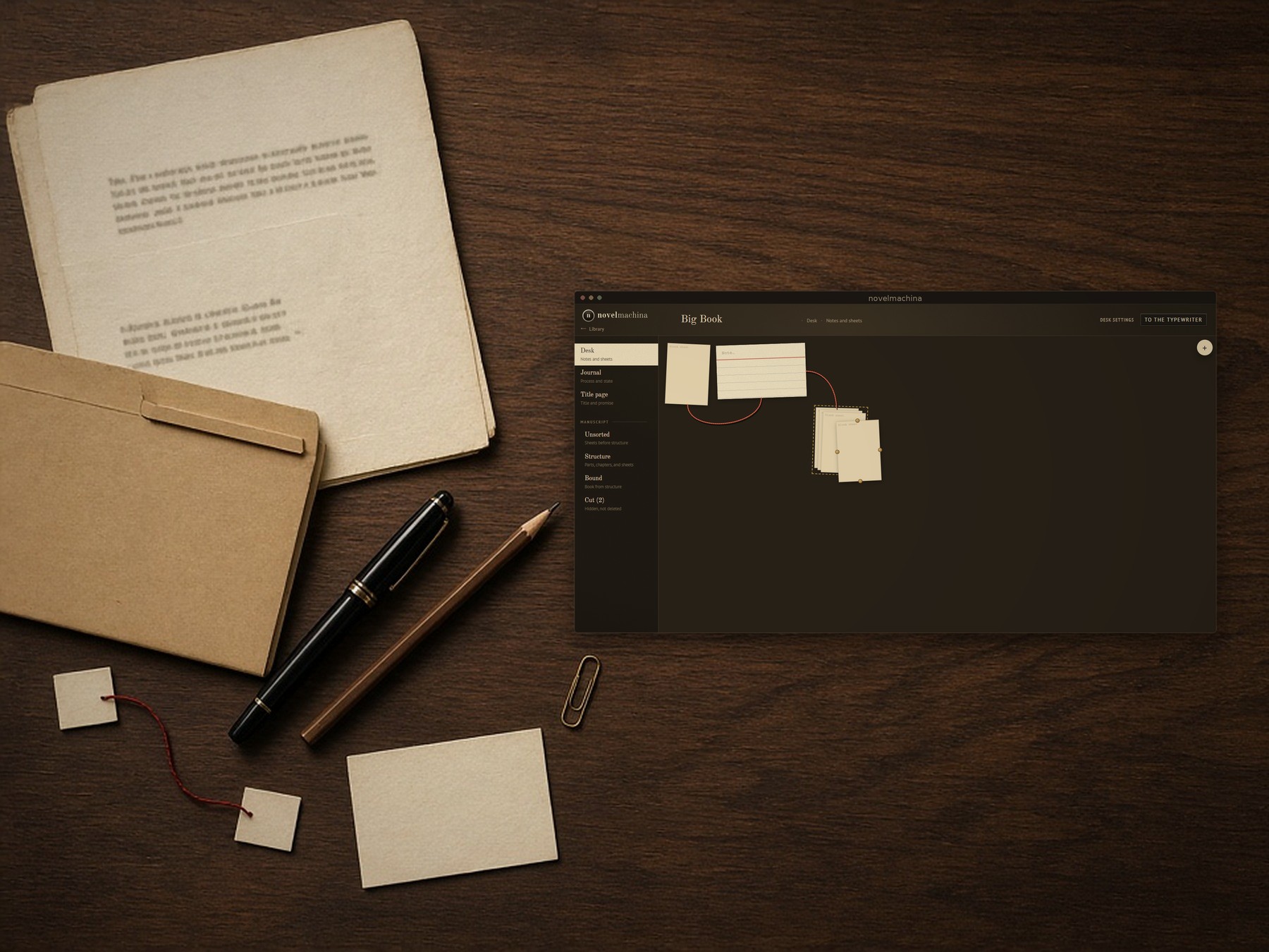 Writer’s desk with manuscript materials and the novelmachina desk screen